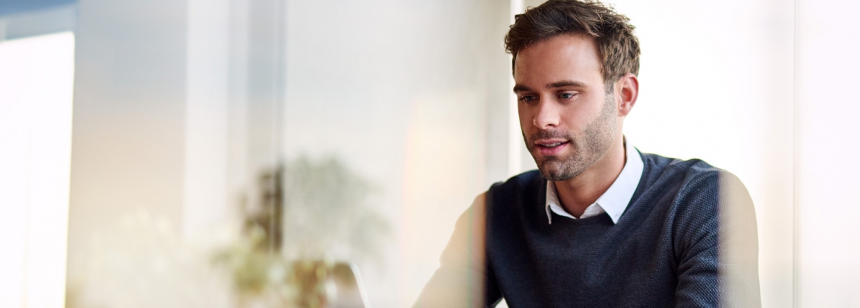 Jonge ondernemer is vanuit huis aan het werk op zijn laptop